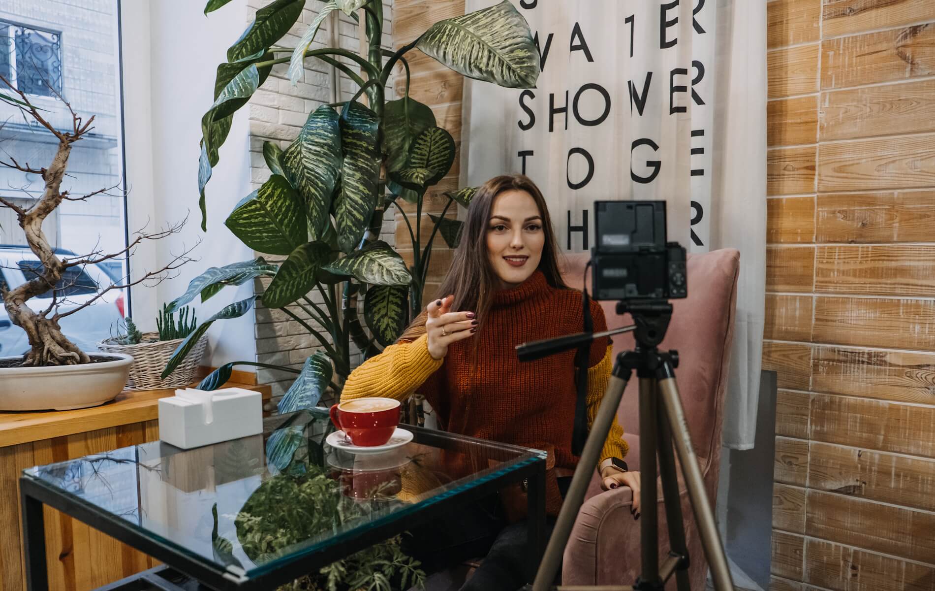 Eine Influencerin nimmt ein Video auf, während sie einen Kaffee trinkt