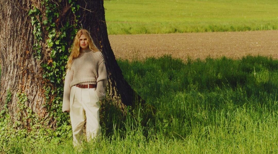 A woman presenting the latest Marc O'Polo collection in front of a tree in a green meadow - influData Marc O'Polo Success Story